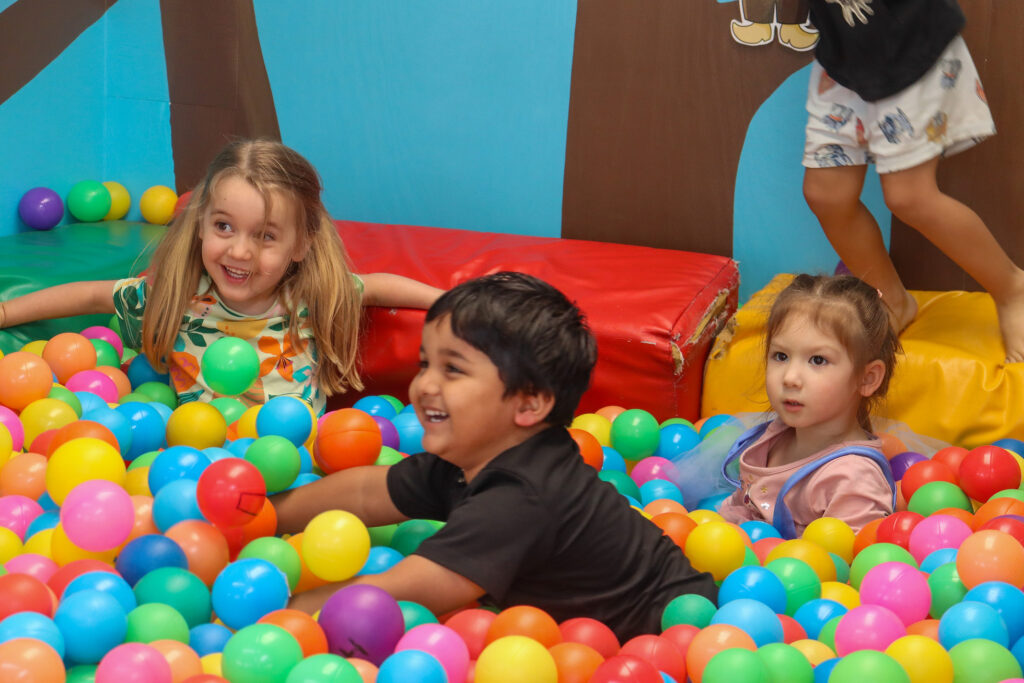 Child engaged in risky play, climbing a tree and building confidence.